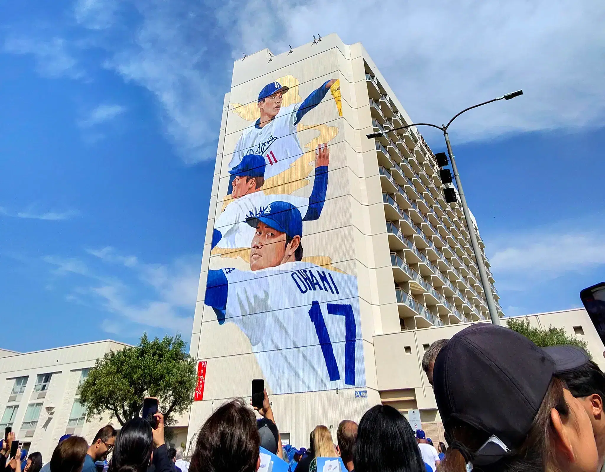 Fans pointing their phones at the Samurai of the Diamond mural